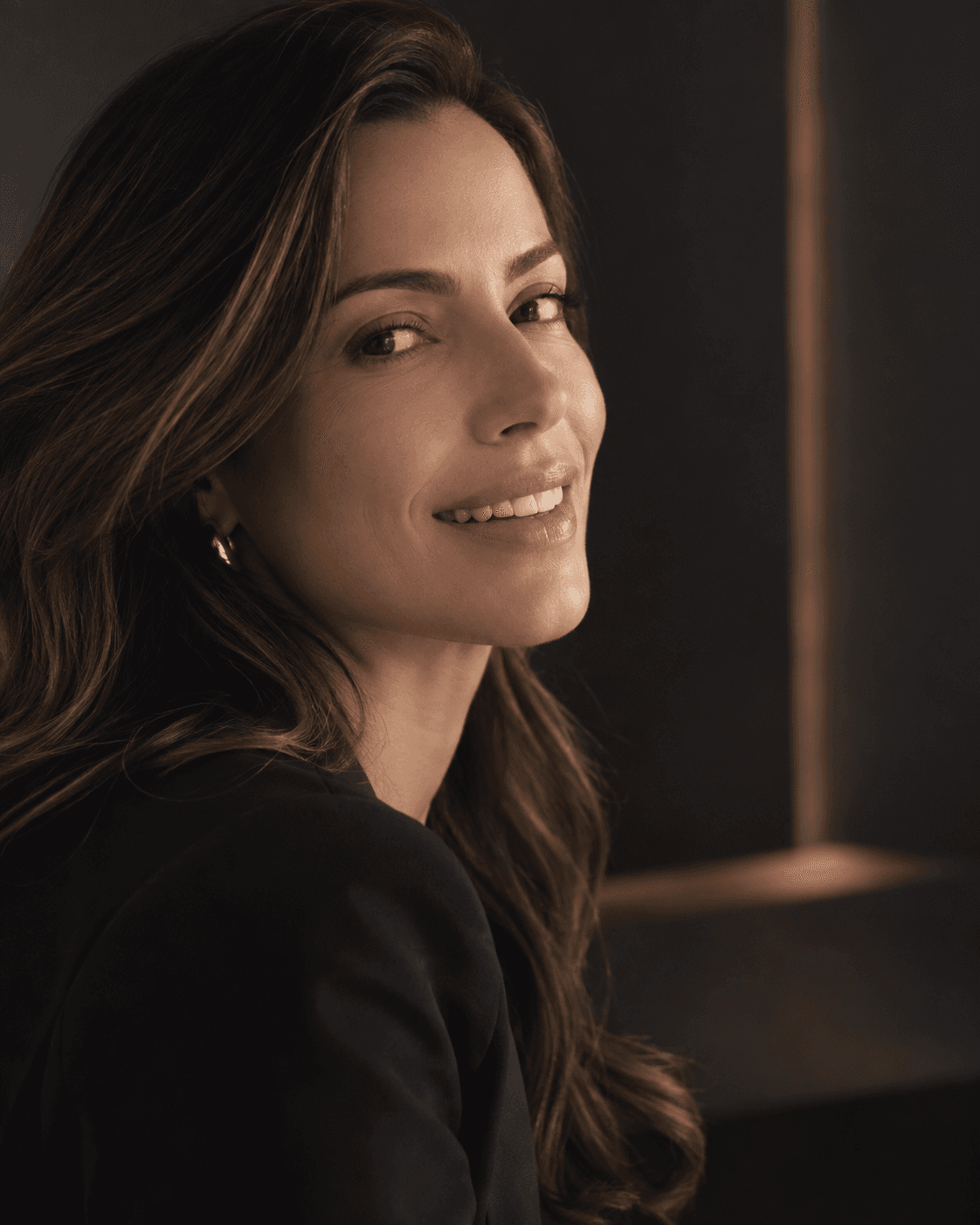 Retrato editorial de uma mulher sorrindo em luz lateral suave